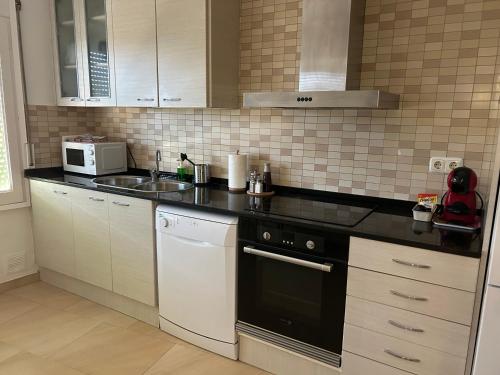a kitchen with a sink and a stove top oven at Apartamento de 3 habitaciones en GIRONELLA - ALBERGA in Gironella