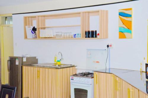 a kitchen with wooden cabinets and a stove top oven at Modern loft overlooking the Lake, Horizon&Sunset in Kisumu