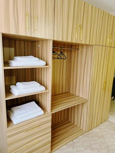 a room with wooden shelves with folded towels at Modern loft overlooking the Lake, Horizon&Sunset in Kisumu