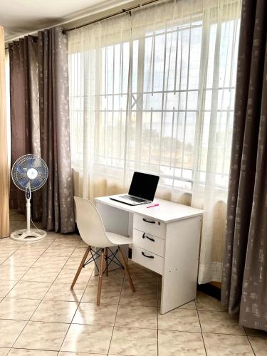 a desk with a laptop on it in front of a window at Modern loft overlooking the Lake, Horizon&Sunset in Kisumu