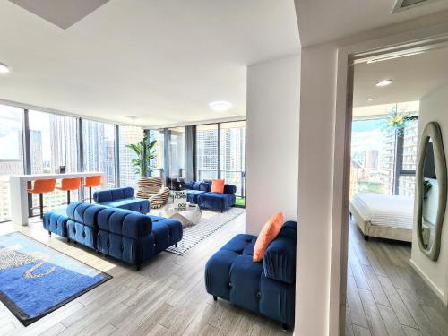a living room with blue couches and a table at 3BR Skyline Luxury with a 100 inch TV, Balcony & Prime Miami Location in Miami