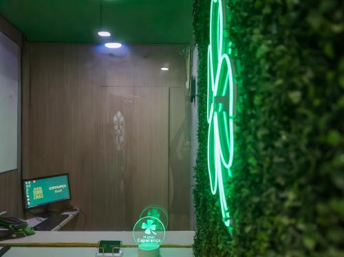 a green neon sign in front of a wall at Hotel Esperança AdultOnly in Rio de Janeiro