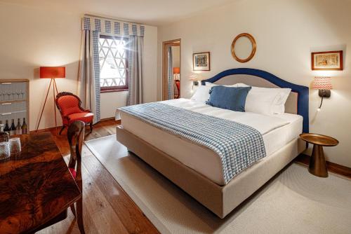 a bedroom with a bed and a table and a chair at Castel Sallegg Suites Adults only in Caldaro