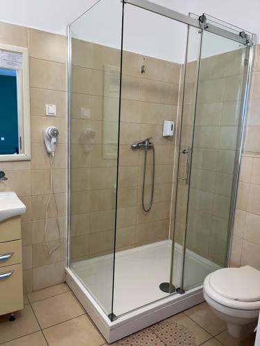 a shower stall in a bathroom with a toilet at City Hotel Bucharest in Bucharest