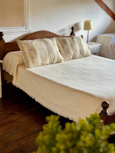 a bed with white sheets and pillows in a bedroom at Curahue Apart Hotel in Tandil
