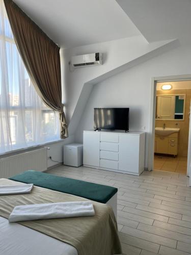 a bedroom with a bed and a tv in a room at City Hotel Bucharest in Bucharest