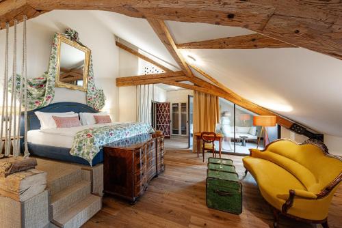 a bedroom with a bed and a chair at Castel Sallegg Suites Adults only in Caldaro