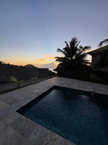 a swimming pool in the middle of a patio at Villa Dézil in Les Anses-dʼArlets