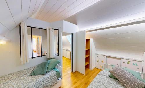 a bedroom with two beds and a large window at Superbe duplex familial Parking Plage à pied in Courseulles-sur-Mer