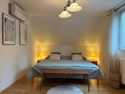 a bedroom with a bed with a blue comforter at Viola Horgász-és Vendégház in Tiszaug