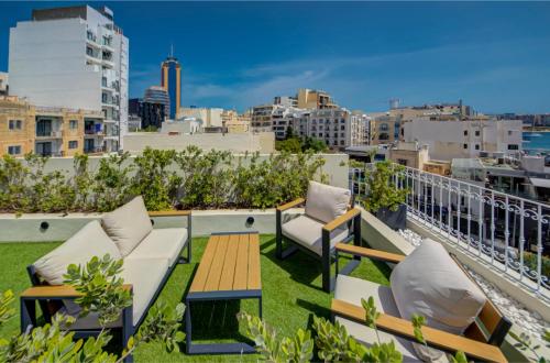 a patio with chairs and a table on a roof at The ultimate luxury triplex home in Spinola Bay by 360 Estates in St Julian's