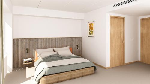 a bedroom with a bed with a wooden headboard at Fjelsted Skov Hotel & Konference in Ejby