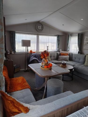 a living room with a couch and a table at Seton Sands Holiday Village Luxury 61 Muirfield Near Edinburgh Free WiFi in Port Seton