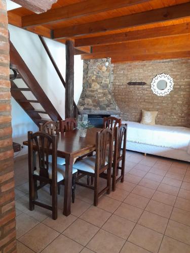 a wooden table and chairs on a patio with a fireplace at Curahue Apart Hotel in Tandil