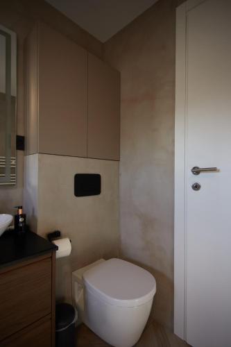 a bathroom with a white toilet and a sink at Lake side story in Frumuşani