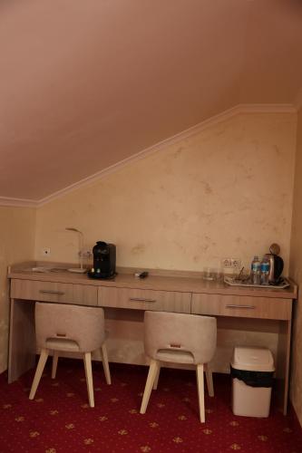 a room with a counter and two chairs at Hotel France in Vinnytsya