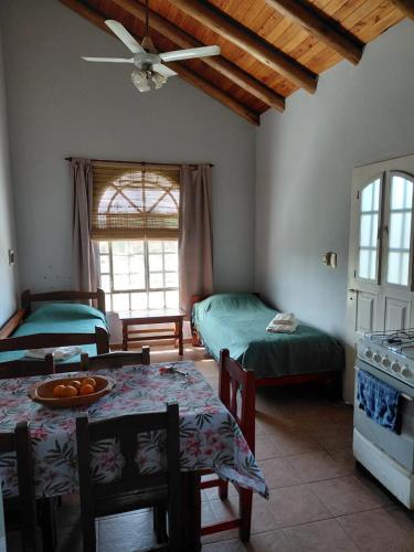 a living room with two beds and a table and chairs at Cabaña 4B Azahares del Ayui in Concordia