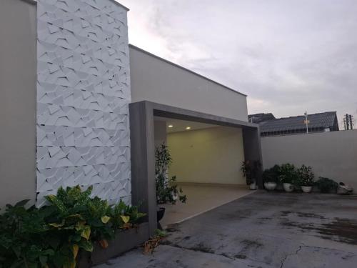 a white house with a garage with plants at Casa da Anita in Boa Vista