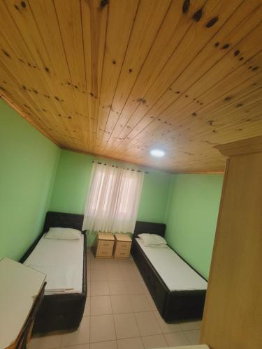 a room with two beds and a wooden ceiling at Villa Rruga 6 Velipoje in Velipojë
