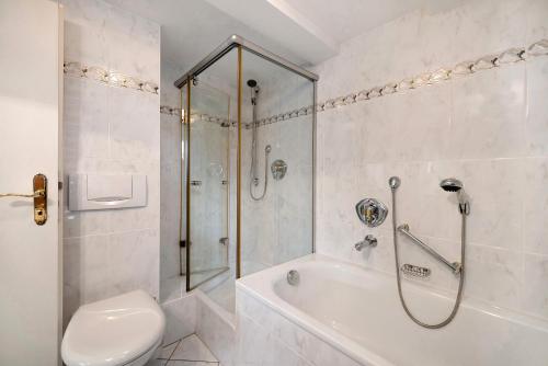 a white bathroom with a shower and a toilet at Appartementhaus Fischer in Lindau