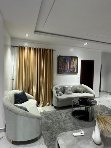 a living room with two couches and a table at Luxury 3 Bedroom Apartment Lekki IKATE in Lekki