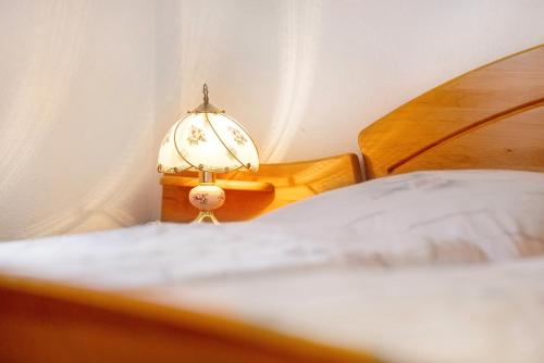 a bed with a lamp sitting next to a bed at Appartementhaus Fischer in Lindau