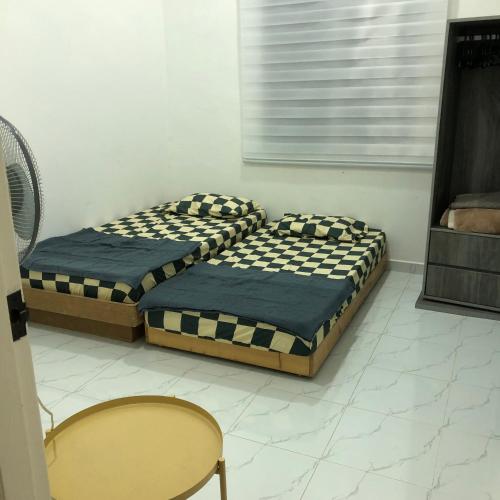 two twin beds in a room with a window at Seribu malam homestay in Bukit Payong