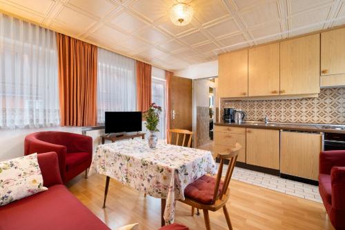 a living room with a table and a kitchen at Appartementhaus Fischer in Lindau