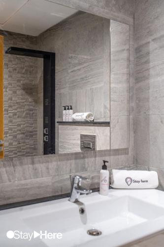 a bathroom with a sink and a mirror at StayHere Agadir - Marina Residential Living in Agadir
