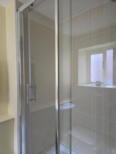a shower with a glass door in a bathroom at Unicorn Hotel Llanidloes in Llanidloes