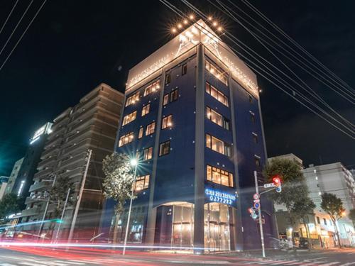 a tall building with lights on top of it at night at リブマックスホステルズ札幌すすきの in Sapporo