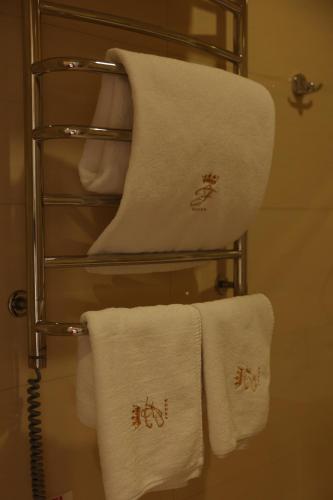 a towel rack with white towels on it at Hotel France in Vinnytsya