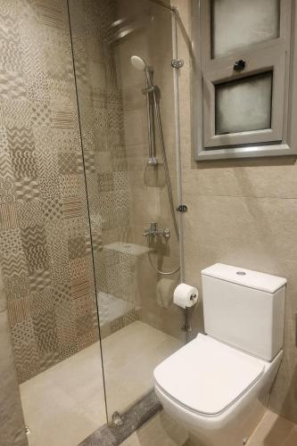 a bathroom with a toilet and a glass shower at Sunny Escape 1BR with Pool Access in Hurghada