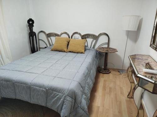 a bedroom with a bed with two chairs and a table at Apartamento Bidaya in Ronda