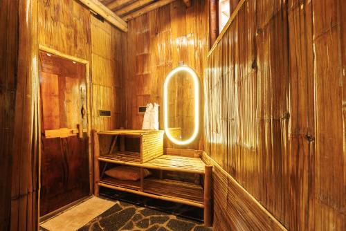 サクルシュプールにあるKaatiKaaduの鏡と木の壁のあるバスルーム