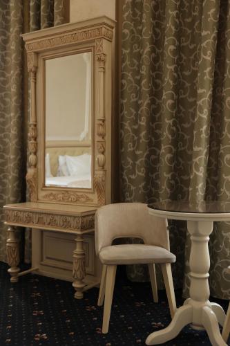 a room with a mirror and a chair and a table at Hotel France in Vinnytsya