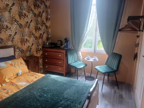 a bedroom with two chairs and a bed and a window at Cherry Blossom House in Bujaleuf