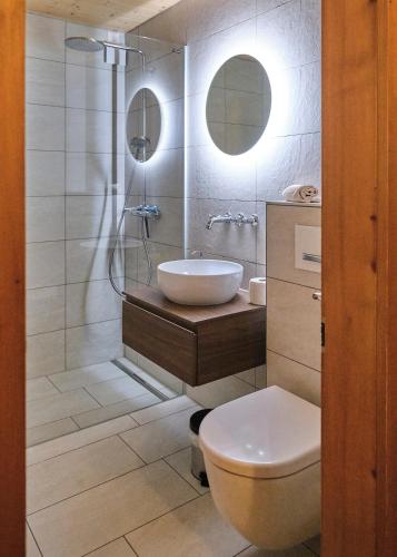 a bathroom with a sink and a toilet and a shower at Cute chalet in Kandersteg in Kandersteg