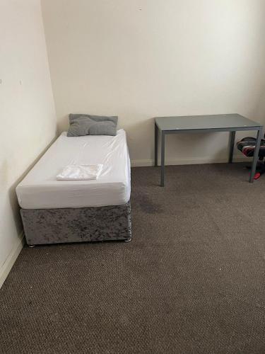 a small room with a bed and a desk at Babo room in Bolton