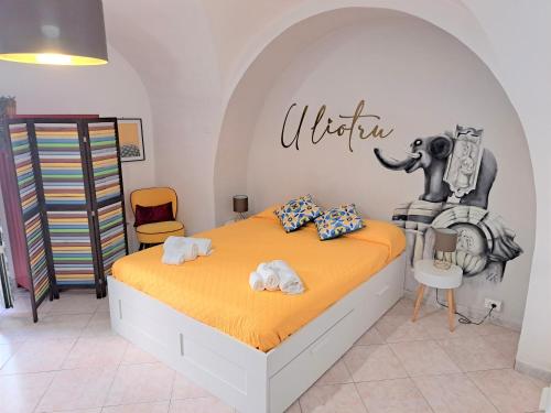 1 dormitorio con 1 cama con un elefante en la pared en U Liotru home, en Catania