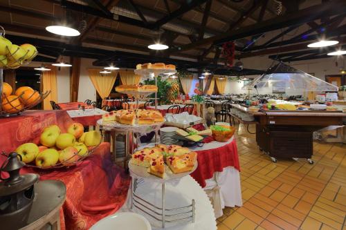 een buffet met veel verschillende soorten eten op tafels bij Village Vacances Passion Georges Moustaki in Les Moussières