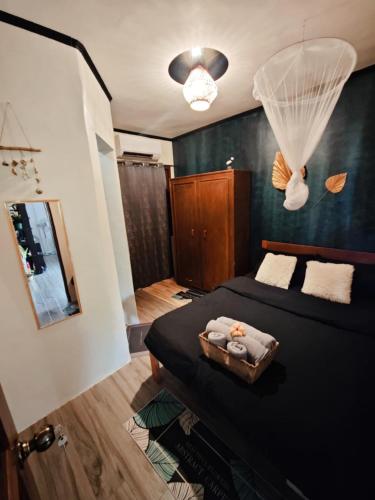a bedroom with a black bed and a mirror at Malinao Blue - Big house for family & groups in General Luna