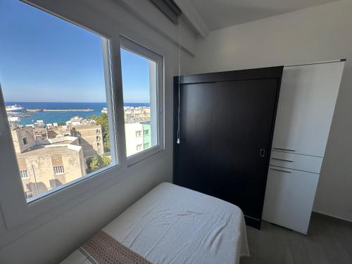 a bedroom with a bed and a large window at North Residence Deniz Manzaralı Daire in Kérynia