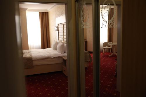 a hotel room with a bed and two windows at Hotel France in Vinnytsya