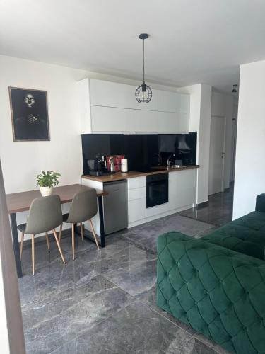 a kitchen and a living room with a table and chairs at Star apartman 3 in Novi Pazar