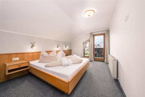a bedroom with a bed with white sheets and a window at das Huber in Mayrhofen