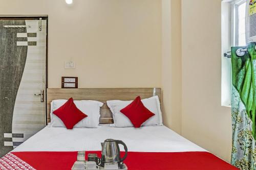 a bedroom with a bed with red pillows at Hotel O Green Palace in Gulzārbāgh