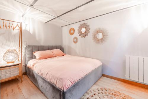 a bedroom with a bed with pink pillows on it at Charming cocon, well-located Apartment 2 rooms in Malakoff