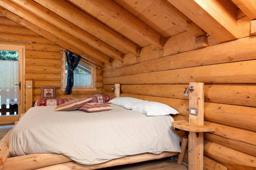 a bedroom in a log cabin with a bed at Agritur Cazzuffi in Peio
