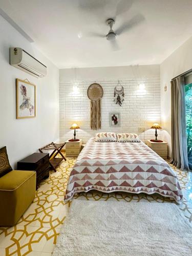 a bedroom with a large bed and a couch at Siboney House by evaddo in Siolim